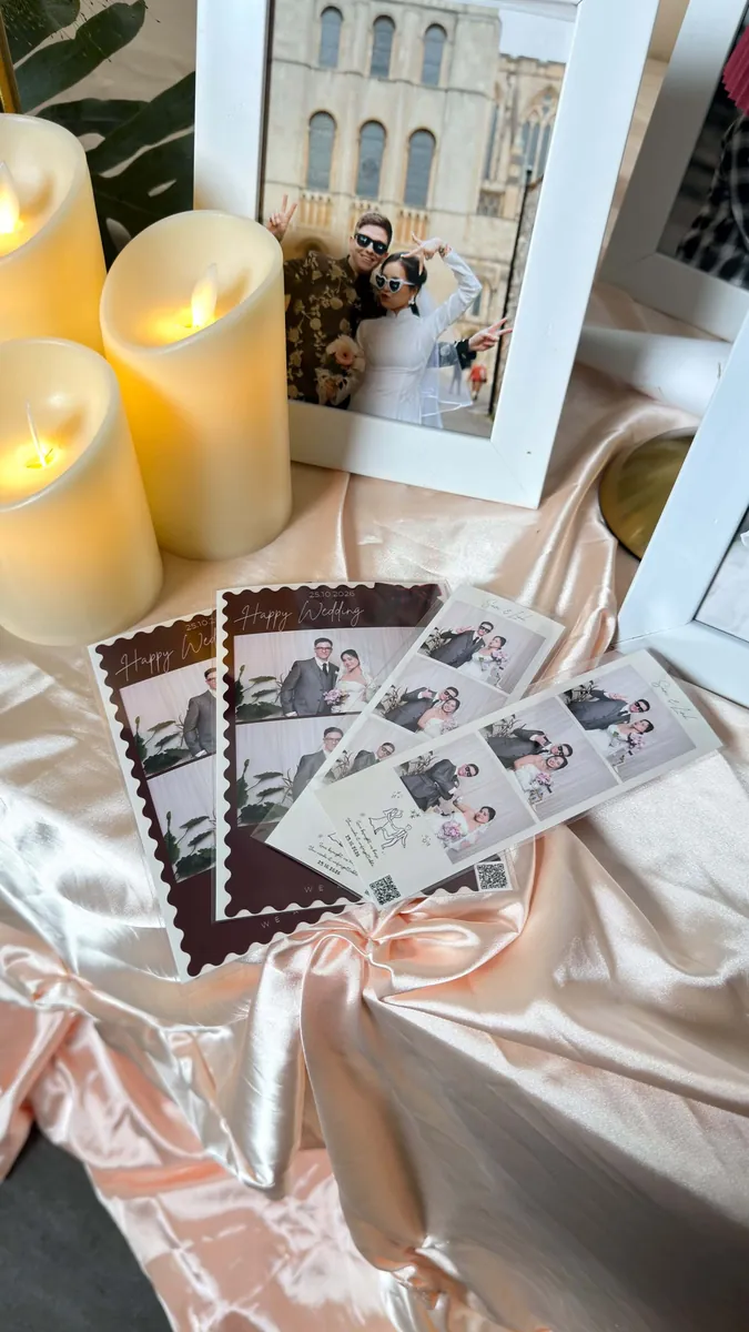 Ảnh in khung đỏ đặt cạnh nến và khung ảnh cưới