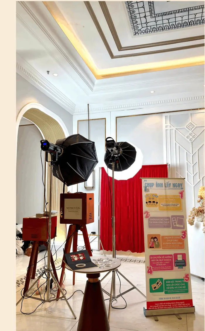 Setup booth với backdrop đỏ và standee hướng dẫn